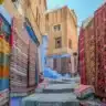 Colorful Moroccan souvenirs like rugs, argan oil, and pottery waiting to be purchased.